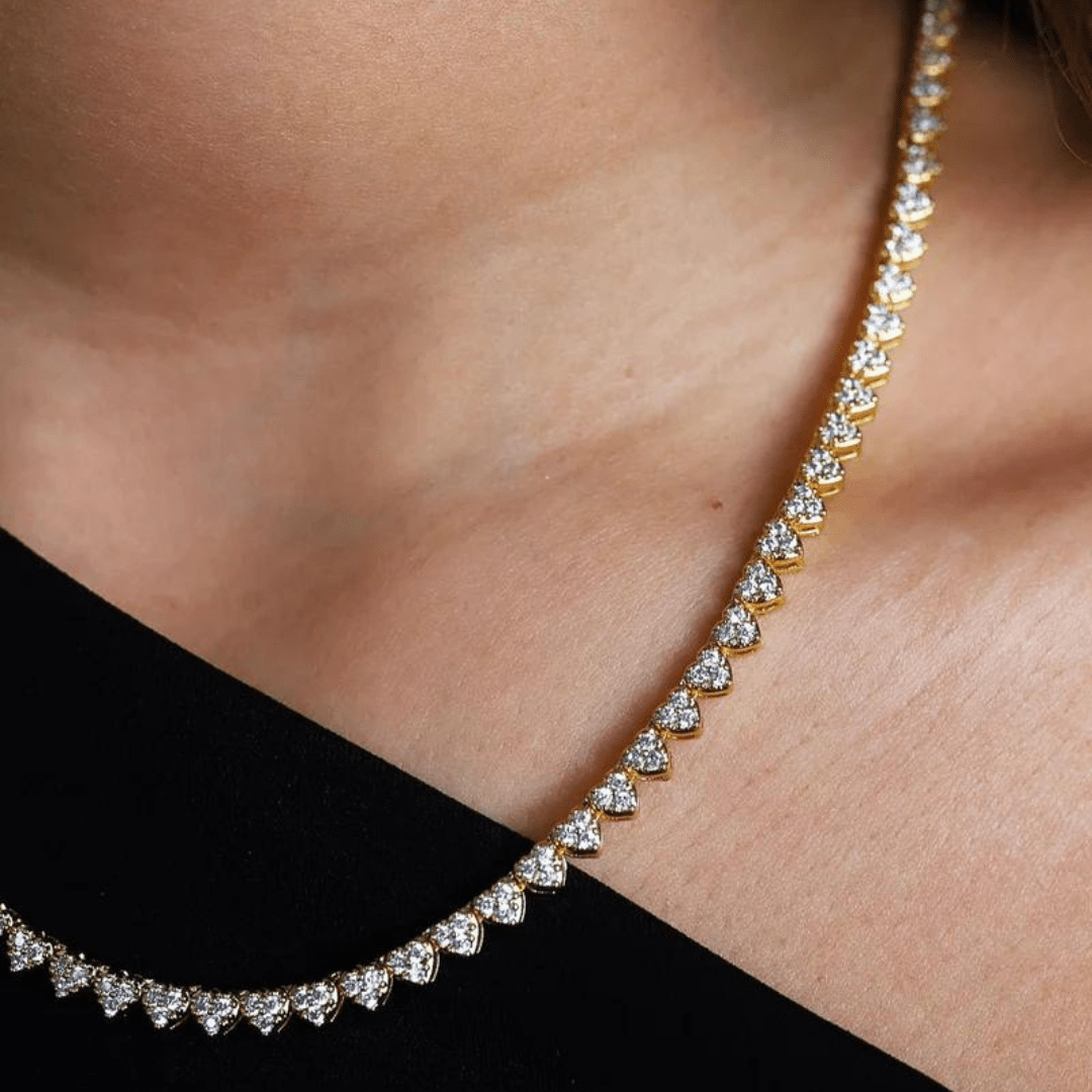 Female model showcasing the Heart Tennis Chain in 18K Gold, featuring 4MM links with distinctive heart-shaped details for a bold and sophisticated accessory.