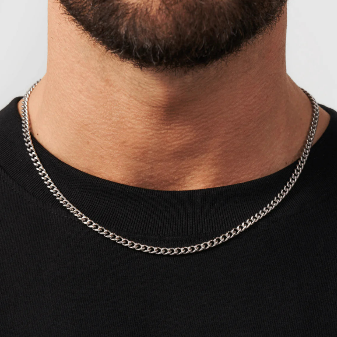 Stylish man wearing a White Gold Cuban Link Chain, 4MM thick, showcasing a luxurious and bold accessory.