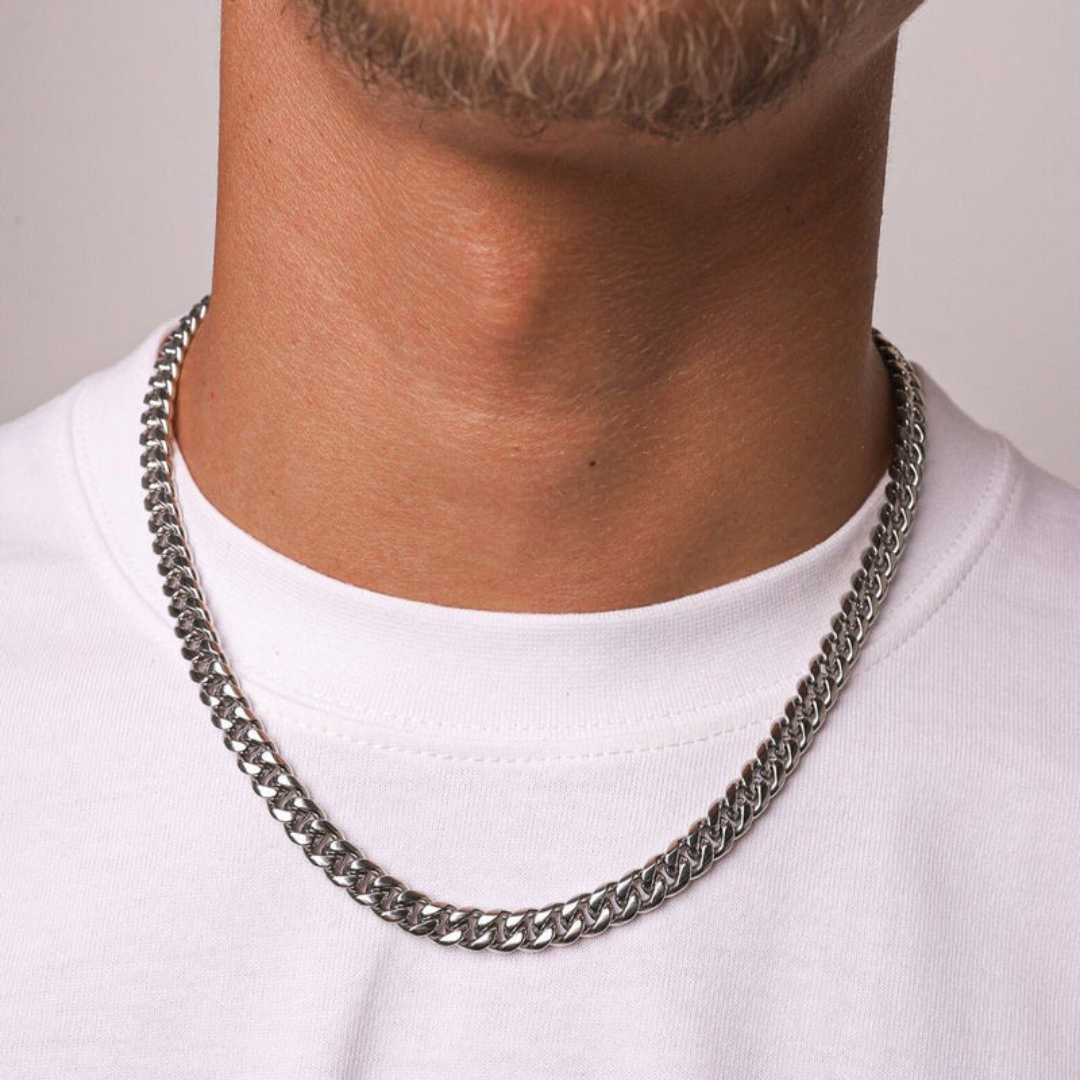 Confident man showcasing a White Gold Cuban Link Chain, 6MM thick, embodying a bold and sophisticated style with this luxury accessory.