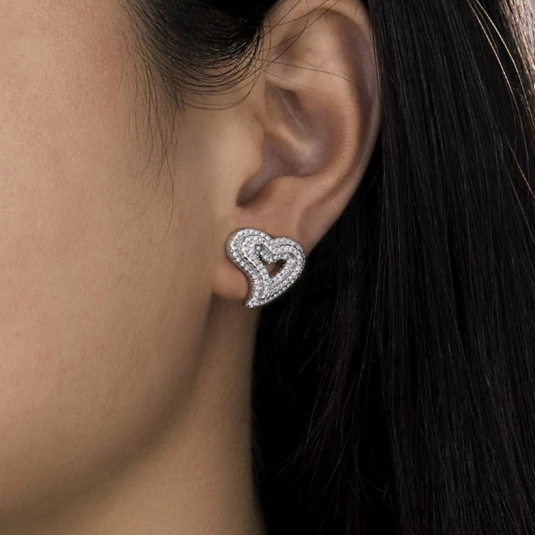 Women's model wearing Heart Stud Earrings in White Gold, highlighting an elegant and chic design with a sleek finish for a timeless and luxurious look.