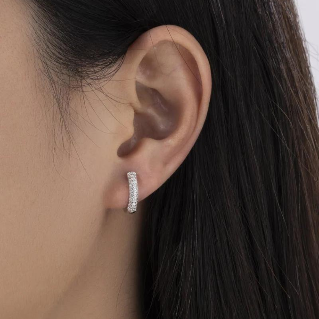 Women's model wearing Hoop Earrings in 925 Sterling Silver with a White Gold finish and Moissanite stones, highlighting a chic and elegant design with sparkling stones for a luxurious and eye-catching look.