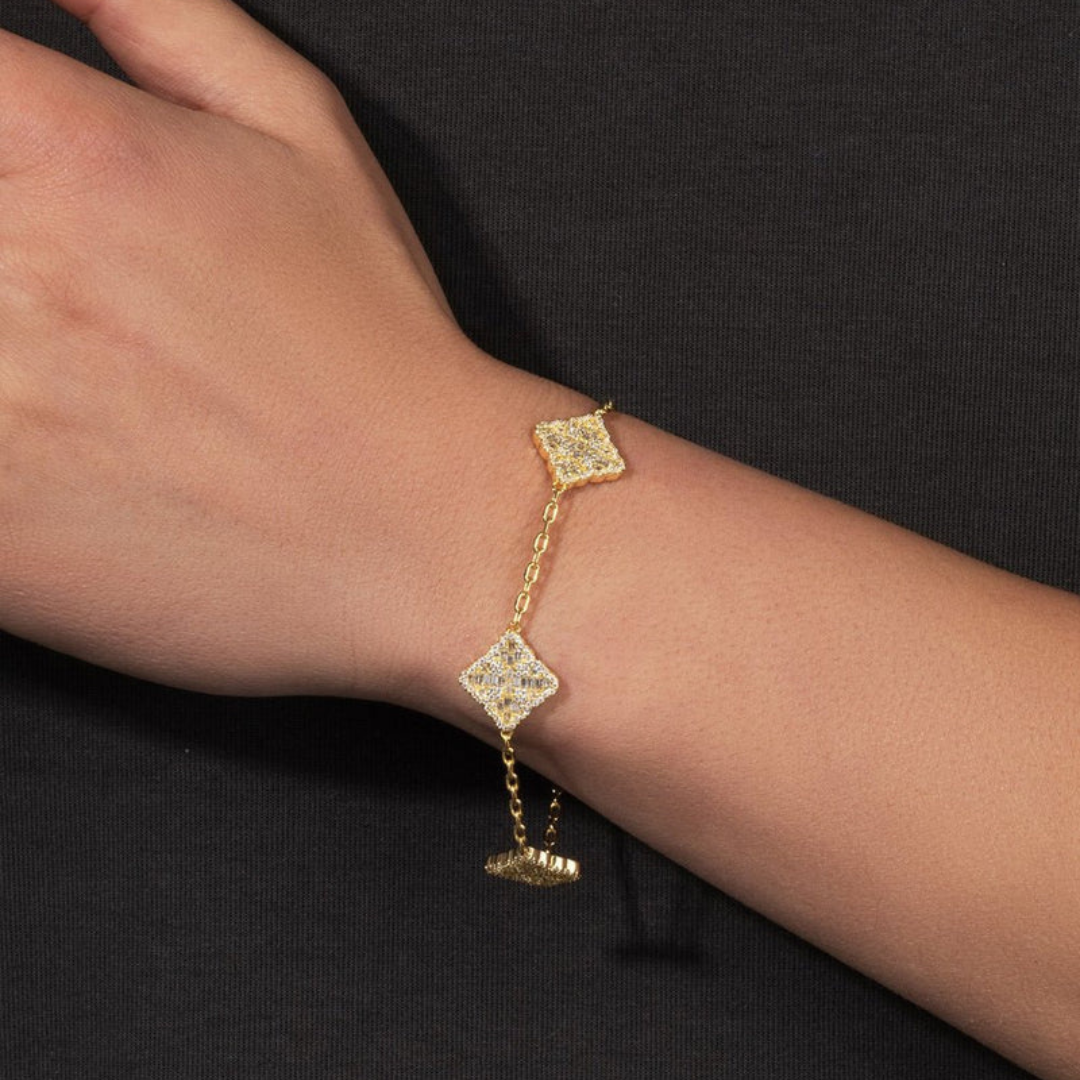 Men's model showcasing the Iced Clover Bracelet in 18K Gold, featuring a distinctive clover design with sparkling gemstones for a bold and sophisticated accessory.