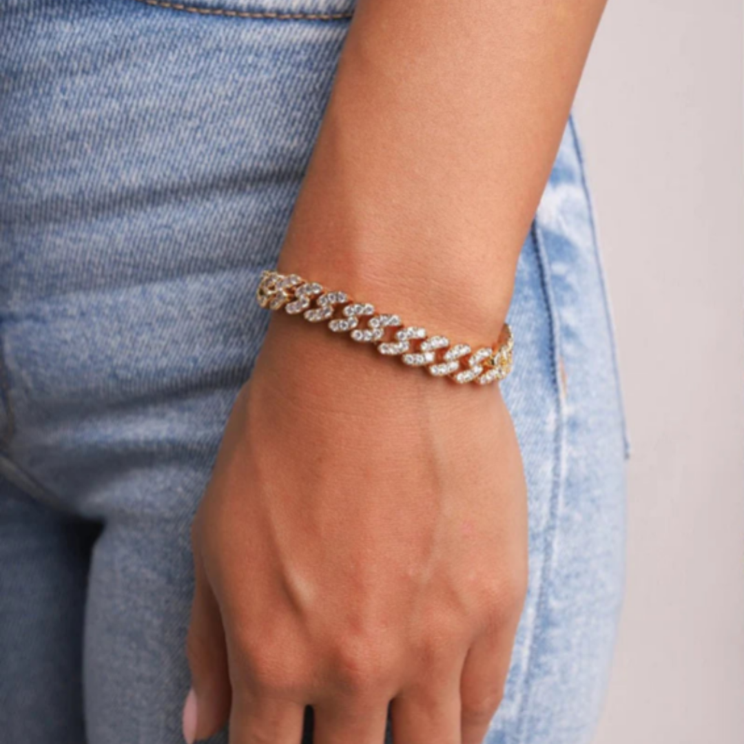 Women's model wearing the Iced Cuban Link Bracelet in 18K Gold with 9MM links, highlighting a chic and luxurious piece with intricate detailing and sparkling gemstones for a refined and stylish appearance.