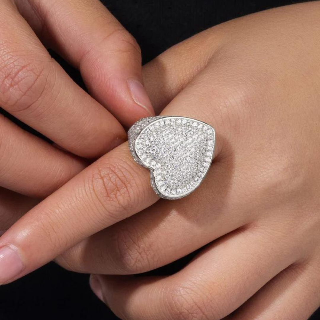 Women's model wearing the Iced Heart Ring in White Gold, highlighting a chic and elegant heart-shaped piece with intricate detailing and sparkling gemstones for a refined and stylish look.