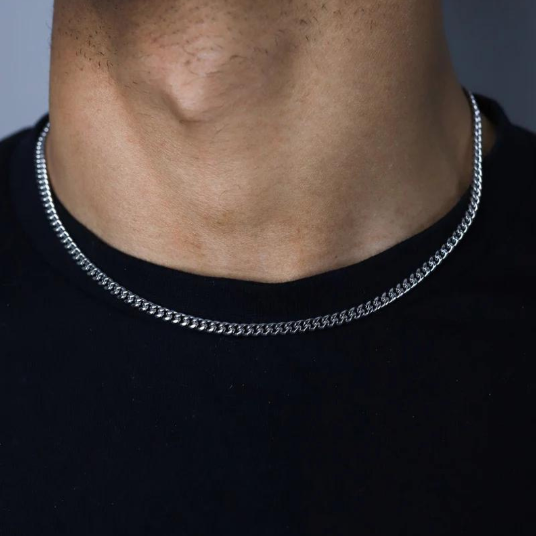 Man wearing a Cuban Link Chain in White Gold, 3MM thick, showcasing a sleek and sophisticated look.