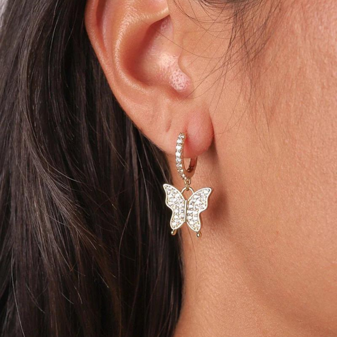 Model wearing 14k gold butterfly earrings, showcasing the elegant design and subtle shimmer of the earrings against a refined, fashionable look.