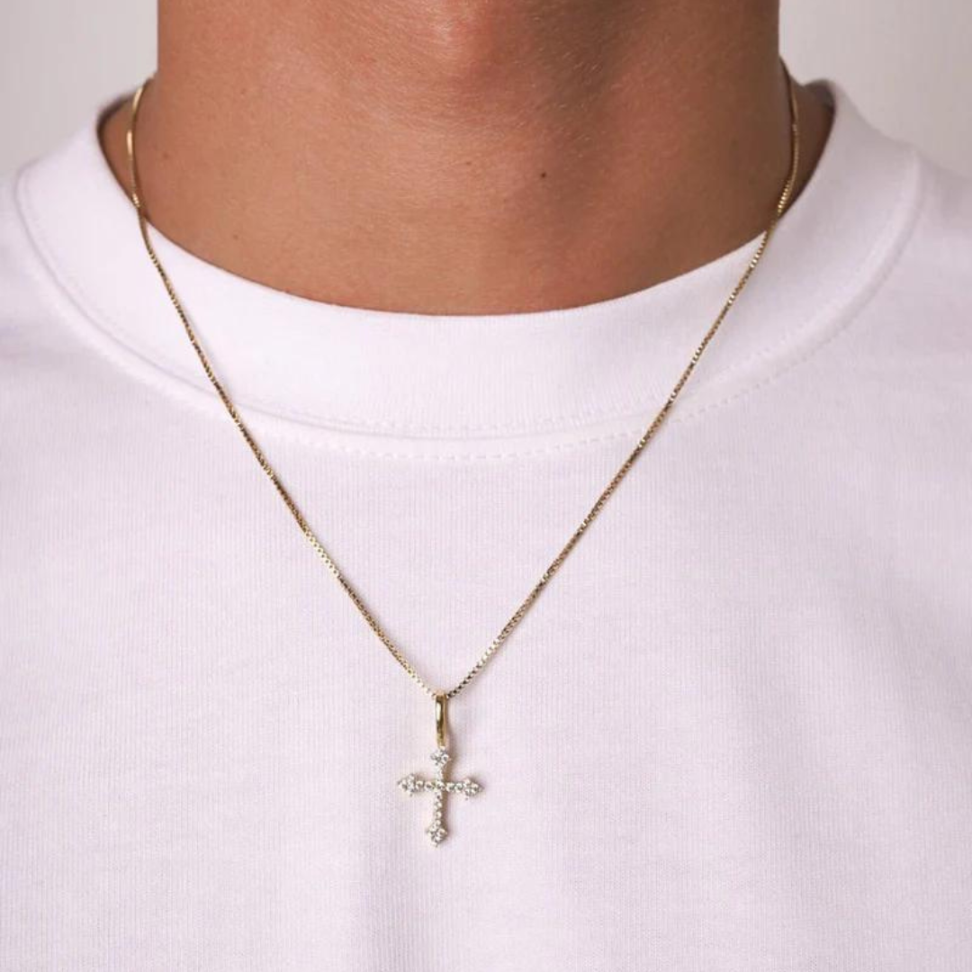 Mens model wearing a 925 sterling silver cross pendant with 14k gold accents, highlighting the elegant design and contrast of metals against a stylish outfit.