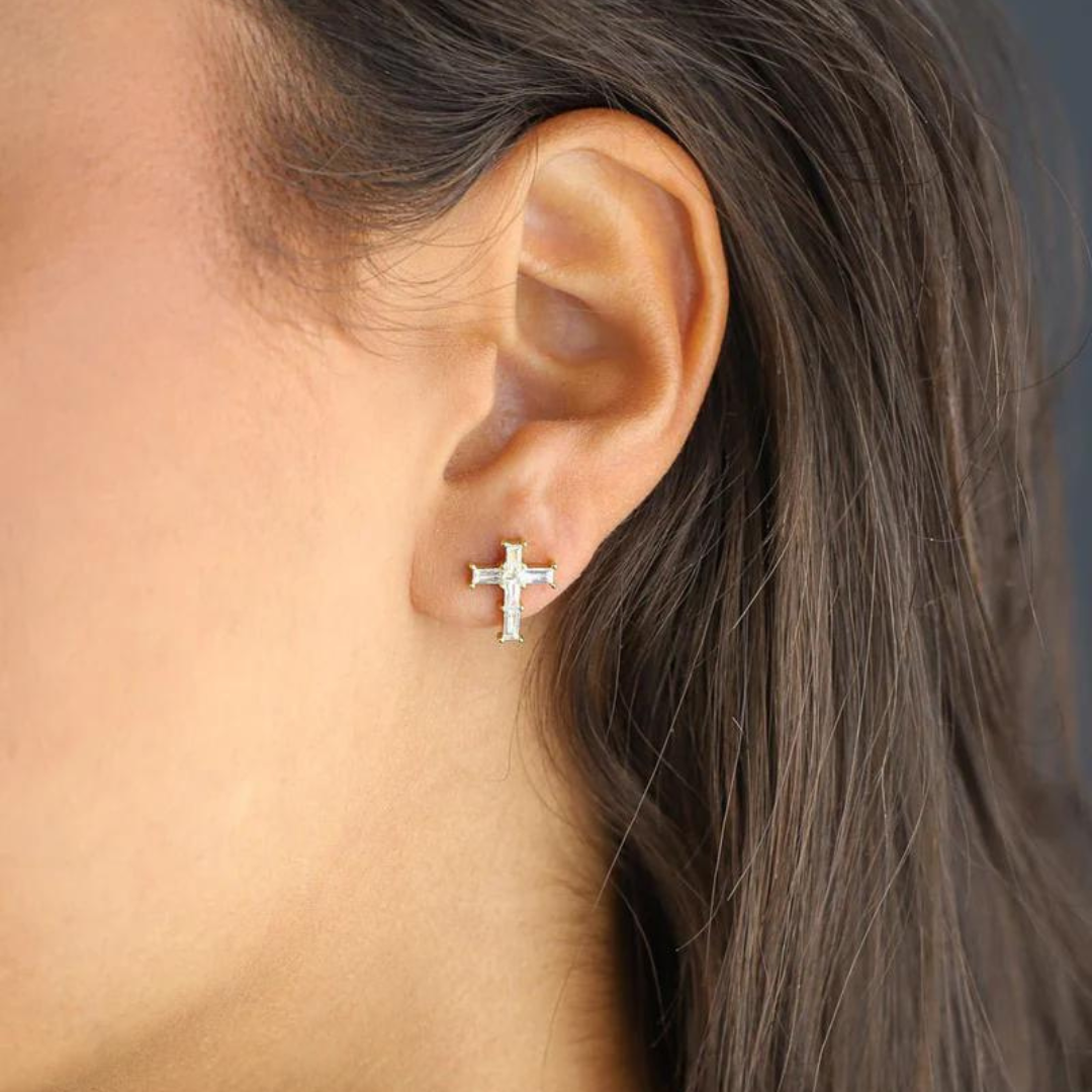 Model wearing 18k gold cross studs, emphasizing their sleek and sophisticated design against a modern and stylish backdrop.