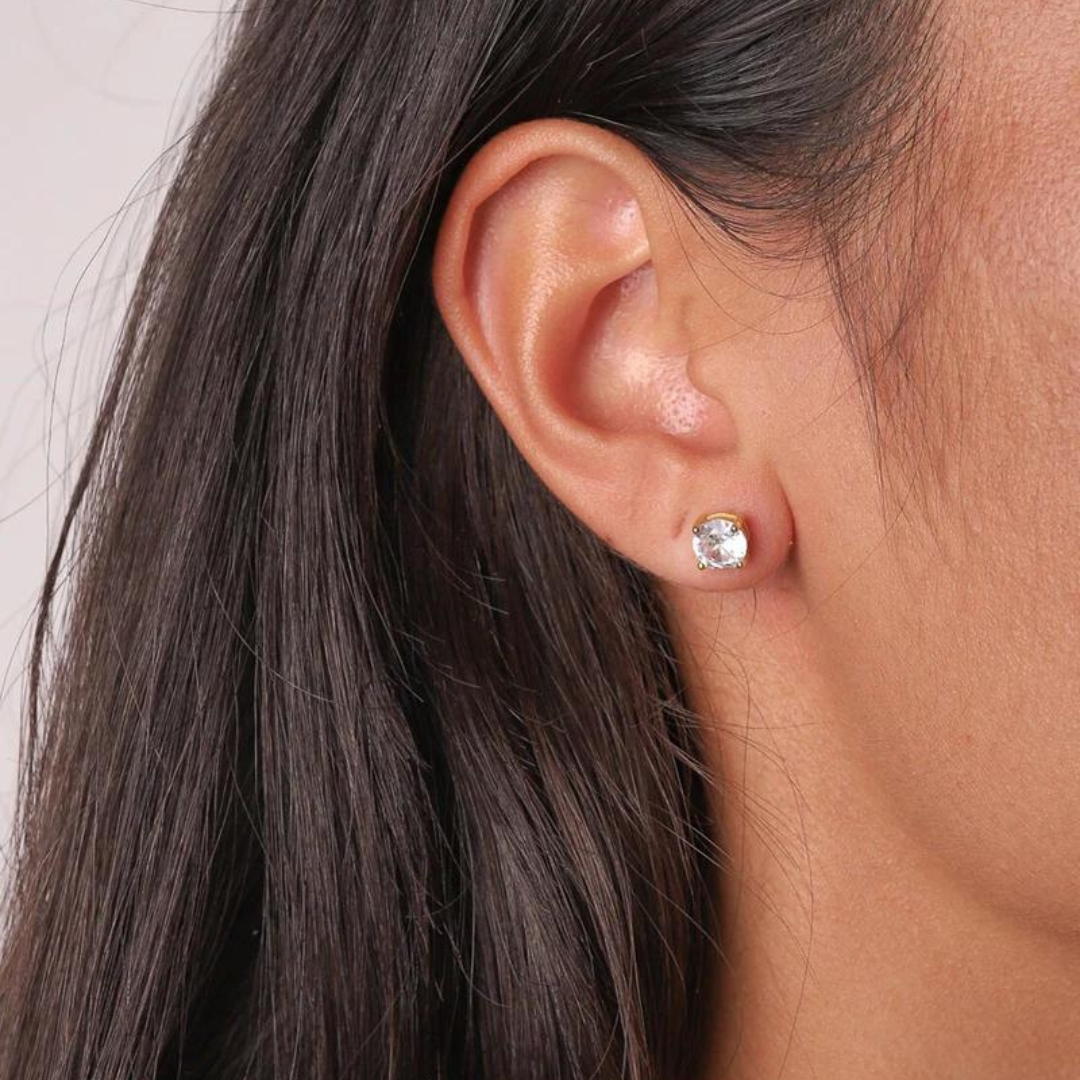 Model wearing 925 sterling silver crystal studs with 18k gold and moissanite accents, highlighting the elegant sparkle and luxurious design against a stylish outfit.