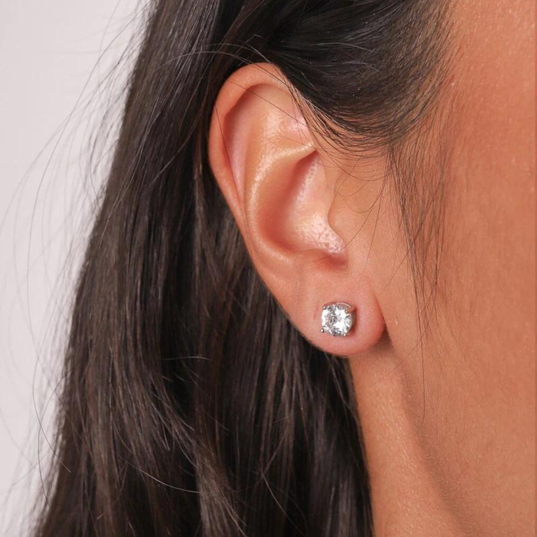 Model wearing 925 sterling silver crystal studs with white gold and moissanite accents, showcasing their elegant sparkle and refined design against a fashionable backdrop.