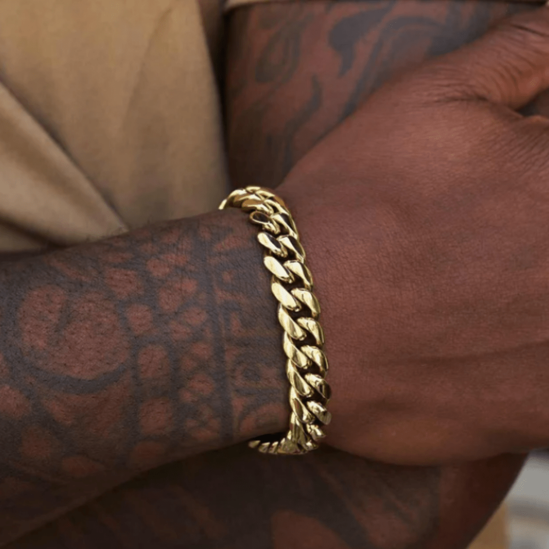 Model wearing an 18k gold Cuban link bracelet with a 12mm width, showcasing its bold design and luxurious shine against a stylish and fashionable outfit.