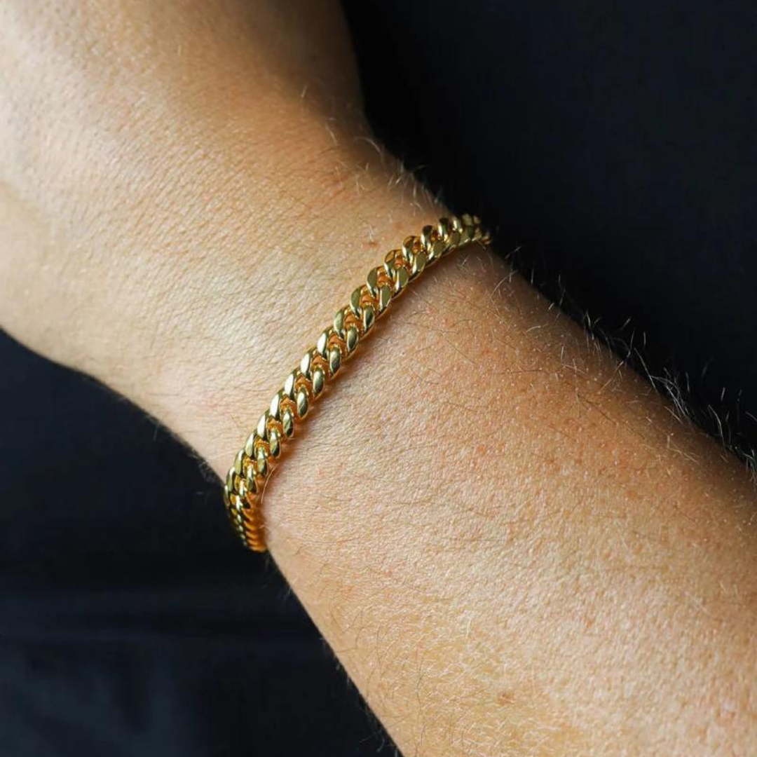 Model wearing an 18k gold Cuban link bracelet with a 6mm width, showcasing its sleek design and elegant shine against a modern, stylish outfit.