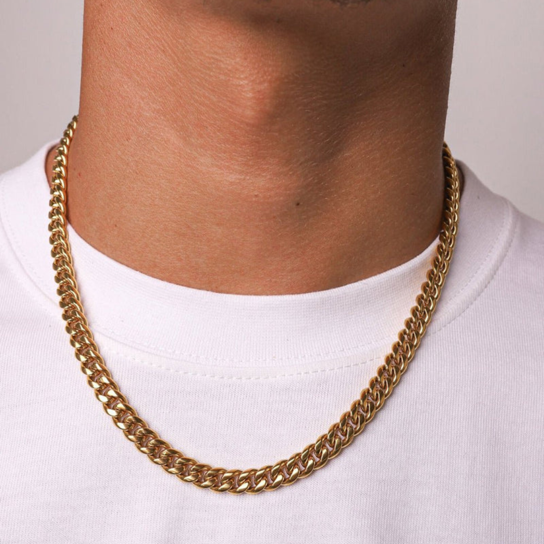 Male model wearing an 18k gold Cuban link chain with a 6mm width, highlighting its bold design and radiant shine against a modern outfit.